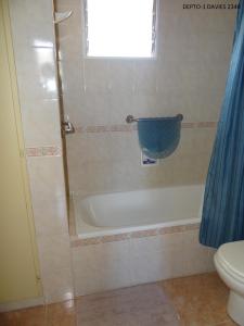 ein Bad mit einer Badewanne, einem WC und einem Fenster in der Unterkunft Temporario Neny in Puerto Madryn