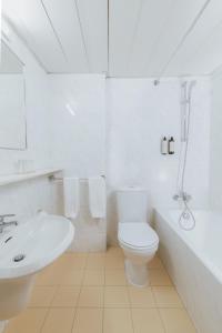 a white bathroom with a toilet and a sink at Odysseia Hotel Kapetanios in Limassol