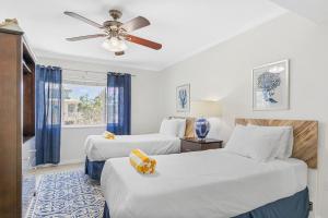 a bedroom with two beds and a ceiling fan at Palm Cay 5 in Holmes Beach +59 photos