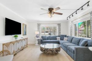 a living room with a blue couch and a tv at Palm Cay 5 in Holmes Beach