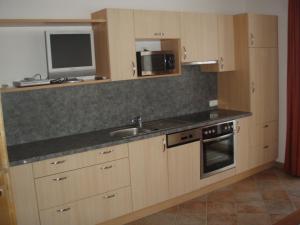 a kitchen with a sink and a microwave at Apart Schultes in Pettneu am Arlberg