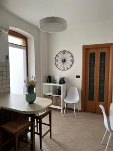 a kitchen with a table and chairs and a clock at Quo Vadis in Gorizia