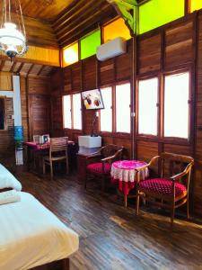 a bedroom with a bed and a table and chairs at Villa Sarimbit Yogyakarta in Yogyakarta