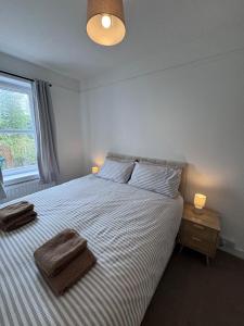 a bedroom with a bed with two towels on it at Helensburgh Central Apartment - Macaulay Letting in Helensburgh +9 photos