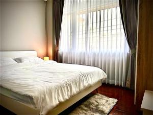 a bedroom with a white bed and a window at The Circle 4 in Bangkok