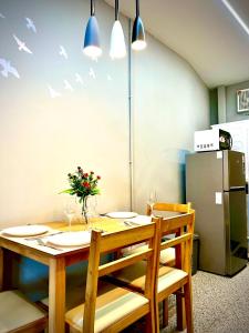 a dining room with a table and a refrigerator at The Circle 4 in Bangkok