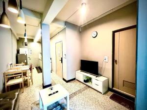 a living room with a tv and a table in it at The Circle 4 in Bangkok