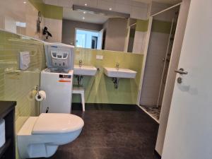 a bathroom with a toilet and two sinks in it at Der Landhof Wolgast in Stolpe auf Usedom +13 photos