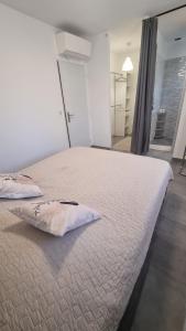 a bedroom with a large bed with a pillow on it at Villa familliale Mornas 4 chambres in Mornas