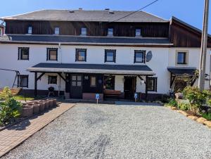 a large white house with a gravel driveway at CASA BENJI - Familienfreundliche FeWo - Landhausstil - Garten - Parkplatz in Pirna