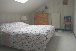 ein Schlafzimmer mit einem Bett, einer Kommode und einem Stuhl in der Unterkunft Maison cosy au cœur de la Vallée des Lacs Xonrupt in Xonrupt-Longemer
