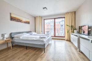a bedroom with a bed and a large window at Waterlane Island Deluxe 5A by Grand Apartments in Gdańsk