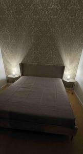 a bedroom with a bed and two tables with lamps at Apartament Mestwina 54 Jurata in Jurata