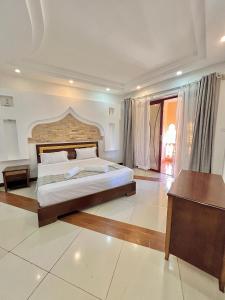 a large bedroom with a large bed and a table at Stunning beachfront 2 bedroom apartment in Mombasa