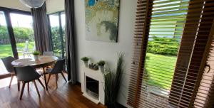 a dining room with a table and chairs and a window at Apartament Mestwina 54 Jurata in Jurata