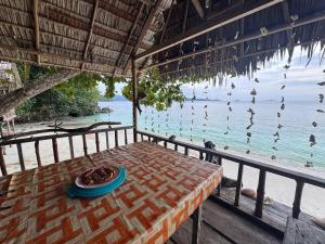 a table with a plate of food on top of the ocean at Kring Kring Homestay in Yennanas Besir
