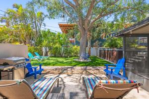 Un patio con sillas y parrilla y un árbol. en Snook Haven, en Clearwater Beach