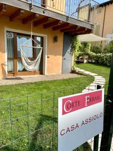 a sign in front of a house with a hammock at Wohnung Mit Privatem Garten Und Schöner Aussicht in Moniga