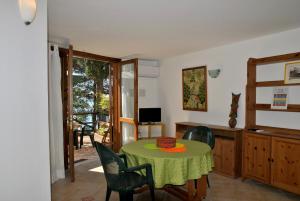 una sala da pranzo con tavolo, sedie e televisione di Casa Elly tra mare e natura a Sperlonga