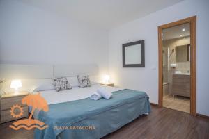 een slaapkamer met een groot bed en een badkamer bij Front Sun Beach Apartment in Valencia