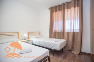 een hotelkamer met twee bedden en een raam bij Front Sun Beach Apartment in Valencia