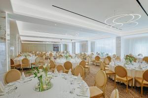 a banquet hall with white tables and chairs at Odysseia Hotel Kapetanios in Limassol +37 photos