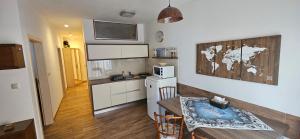 a small kitchen with a table and a microwave at Chopok Juh apartmán Yeti in Horná Lehota +6 photos