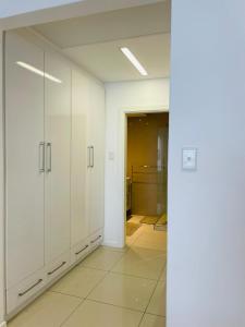 an empty room with white cabinets and a hallway at iTowers Luxury Apartment in Gaborone