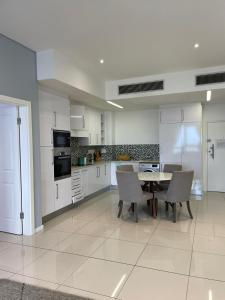 a large white kitchen with a table and chairs at iTowers Luxury Apartment in Gaborone