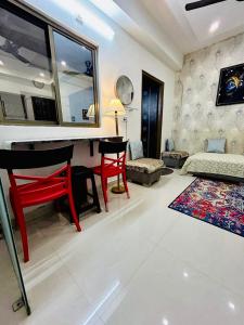 a living room with a desk and a red chair at Namah 1 BHK Resort Homestay with KITCHEN -4 min from Prem Mandir in Vrindāvan