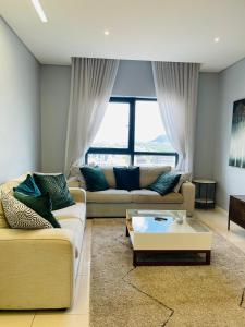 a living room with two couches and a coffee table at iTowers Luxury Apartment in Gaborone