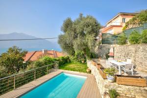 a swimming pool in a garden with a table at Lake View Villa Mercurio with Shared Pool in Brenzone sul Garda