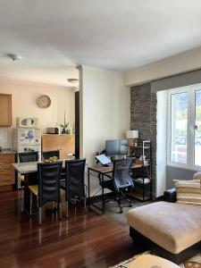 a kitchen and living room with a table and chairs at Surf Nest in Machico