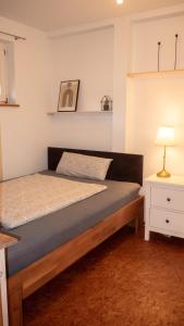 Apartment Rietheim في Rietheim-Weilheim: غرفة نوم بسرير وموقف ليلي ومصباح