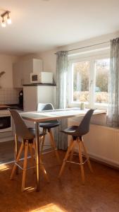 Apartment Rietheim في Rietheim-Weilheim: مطبخ مع طاولة وكراسي ونافذة