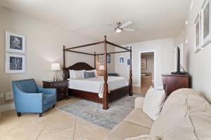 Un dormitorio con una cama con dosel y un sofá. en Turquoise D1703, en Orange Beach