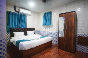 a bedroom with a bed and a mirror and blue curtains at Nexus Corporate Stay in Navi Mumbai +20 photos