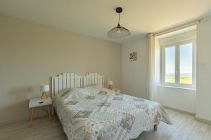 a white bedroom with a bed and a window at Gîte de Lucie - Climatisé avec jardin de 800 m² in Lunac +8 photos