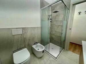a bathroom with a toilet and a glass shower at Arcobaleno B in Faenza