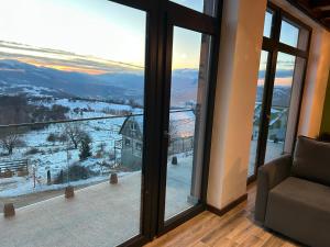 a living room with a view of a snowy mountain at Cabana Panoramic in Jieţ