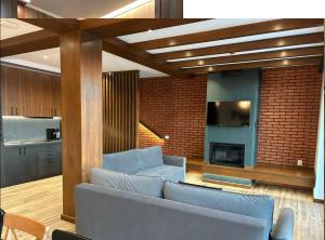 a living room with a blue couch and a brick wall at Cabana Panoramic in Jieţ