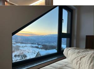 a bedroom with a window with a view of a snow covered at Cabana Panoramic in Jieţ