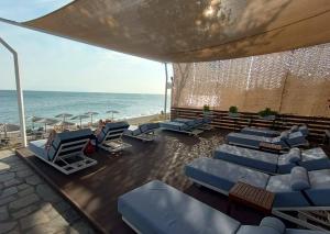 a patio with chairs and the ocean in the background at Sea Breeze Alexandroupolis in Alexandroupoli