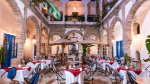 a restaurant with tables and chairs and umbrellas at Riad Al Madina in Essaouira