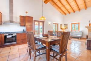 a kitchen with a wooden dining table and chairs at Finca can Mandai in Son Carrió