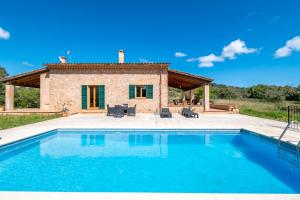 a villa with a swimming pool in front of a house at Finca can Mandai in Son Carrió
