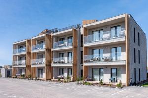 an apartment building with balconies on a parking lot at Seaside Stay in Palanga