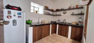 a kitchen with wooden cabinets and a white refrigerator at Caraz Miski Wuasi in Caraz