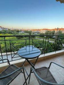 une table et deux chaises sur un balcon dans l'établissement Sunny Escape - Cottage in Moudania Chalkidiki, à Nea Moudania