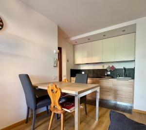 a kitchen with a wooden table and chairs at Il Moro di Cavalese in Castello di Fiemme